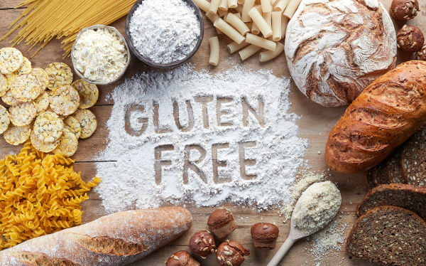 Glutenfreies Essen. Verschiedene Nudeln, Brot, Snacks und Mehl auf Holzhintergrund von Draufsicht